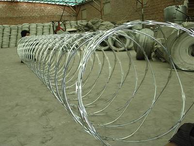 A line of galvanized concertina razor wire in the warehouse with several packed razor wires in the warehouse.