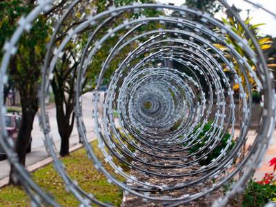 A line of mobile razor wire is installed on the wall separated the street and garden.