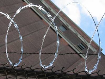 Concertina wire and barbed wire installed on chain link fence forming security fencing